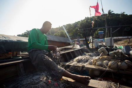 Koh Yao, Thailand; 1st January 2023: Fisherman in Koh Yao fishing village preparing nets to catch fish.のeditorial素材