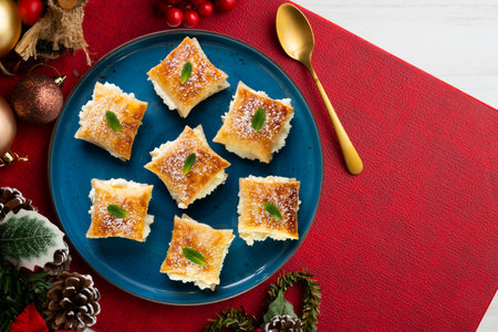 Miguelitos de la Rueda. Traditional Spanish dessert made with puff pastry and cream filling. Christmas food served on a table decorated with Christmas motifs.の写真素材