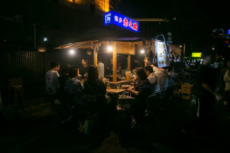 Fukuoka, Japan; 1st October 2023: People eating and drinking in a Yatai in Hakata Bay. A Yatai is a small, mobile food stall in Japan typically selling ramen or other food.のeditorial素材