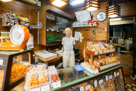 Tokyo, Japan 1st October 2023: Woman at the counter of a crispy rice cake shop in Yanaka in Japan.のeditorial素材