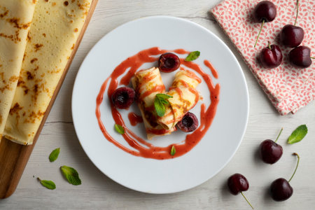 Delicious French crepes with fresh cherries and red fruit syrup.の写真素材