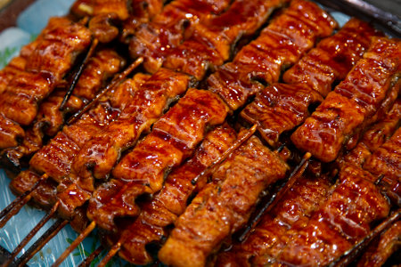 Roasted skewered eel at a food market in the city of Osaka in Japan.の写真素材