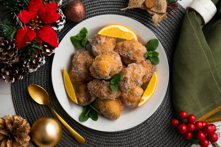 Delicious traditional Spanish fritters. Table decorated with Christmas decorations.