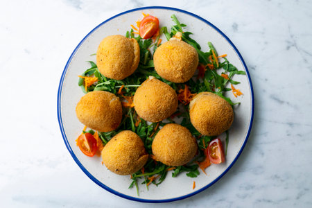 Spanish Tapa croquettes made with bechamel sauce and stuffed with iberian ham. Top view table.