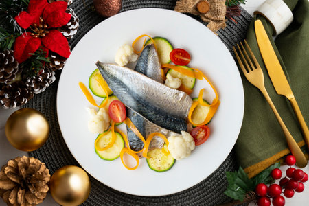 Baked mackerel with delicious and healthy vegetables. Top view table with christmas decorations.の写真素材