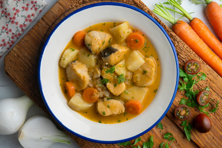 Hake stew with potatoes and carrots. Top view table with decorations.の写真素材