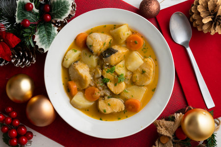 Hake stew with potatoes and carrots. Top view table with Christmas decorations.の写真素材