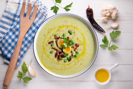 Cream of green beans with Iberian ham and quail egg. Top view table with decoration.の写真素材
