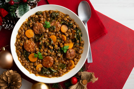 Lentil stew with chorizo, spinach and carrot. Top view table with Christmas decorations.の写真素材
