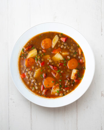 Spicy stewed lentils with vegetables and potatoes. Top view table with decoration.の写真素材