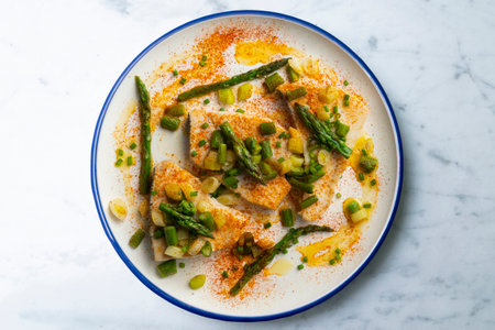 Grilled swordfish with green asparagus. Top view table with decorations.
