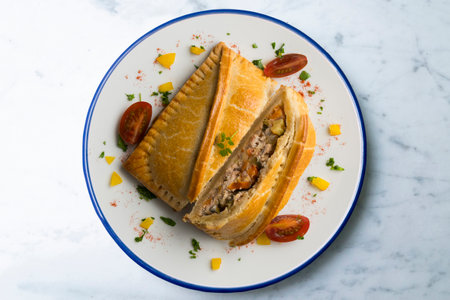 Galician empanada with vegetables and fish. Top view table with decorations.