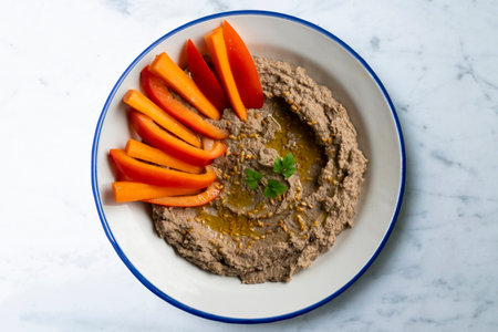 Lentil hummus with carrot and pepper crudites. Top view table with decorations.