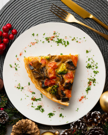 Piece of roasted vegetarian vegetable quiche. Top view table with Christmas decorations.の写真素材
