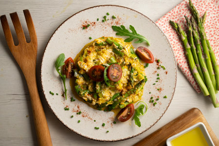 Scrambled organic chicken eggs with green asparagus and tomato. Top view table with decoration.の写真素材