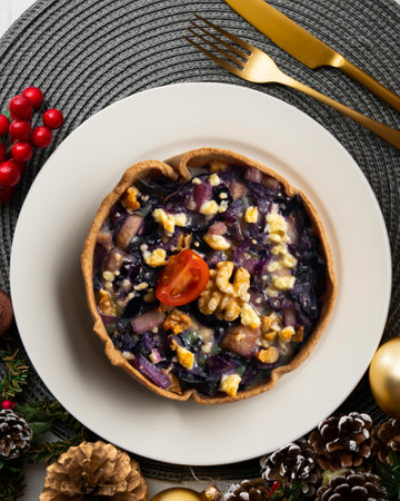Individual vegan quiche with vegetables and red cabbage. Top view table with christmas decoration.の写真素材