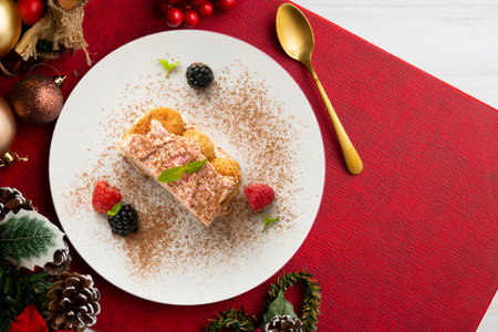 Italian tiramisu with red berry cream. Top view table with Christmas decorations.