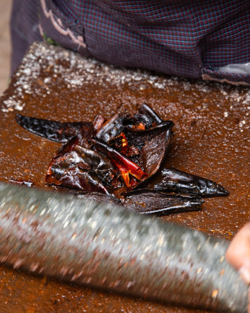 Preparing Mexican Mole Negro. Oaxaca chiles have to be cleaned, toasted on a comal over a flame and soaked in water before grinding with metate.の写真素材