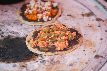 Cooking memelas in Oaxaca Central de Abastos Market with local cheese, pork and vegetables.