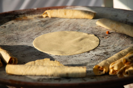 A woman cooking tortillas, flautillas and Mexican memelas on a comal on a street in Oaxaca.の写真素材
