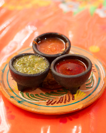 Handmade clay plate with 3 different types of Mexican hot sauces.の写真素材