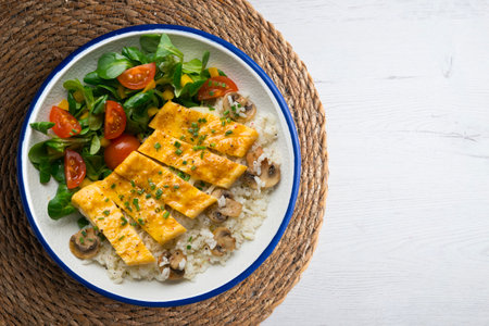 Dish with an omelet filled with rice and salad. Top view table.の写真素材