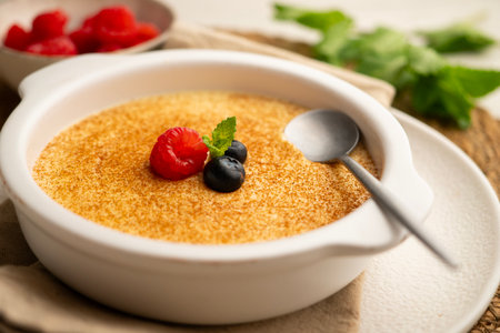 Egg custard with ginger aroma and decorated with ground cinnamon and red berries.の写真素材