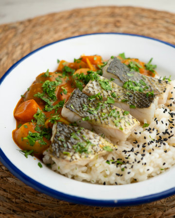 Sea bass with red vegetable curry and white rice.
