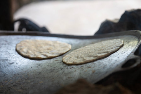 Traditional corn tortillas cooking on a comal over an open wood fireの写真素材