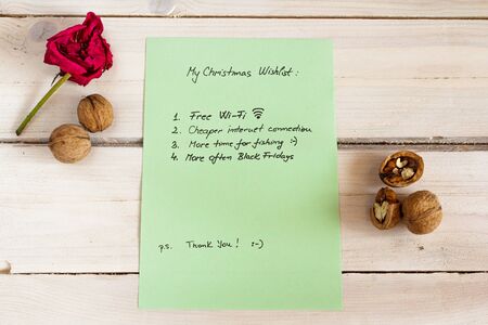 Funny christmas list for Santa on a white natural wooden background, green paperの写真素材