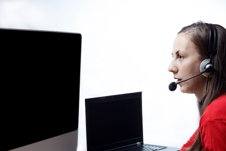 Young girl wearing headset in fornt of two monitors at a Public Safety Answering Point