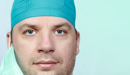 Adult male doctor portrait close up on green blue backgroundの写真素材