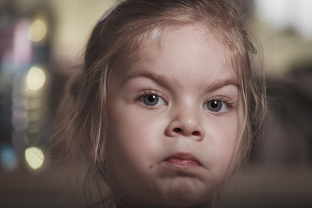 Portrait of a young baby girl with focus on the eyes, facial expressionの写真素材