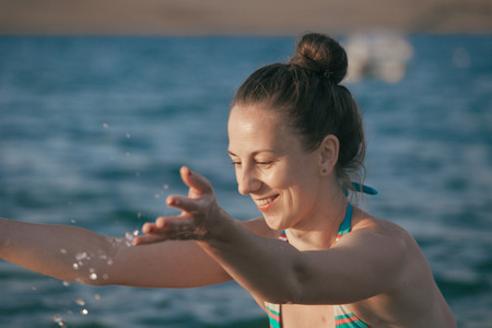 Young female having fun in the water, joy of summer near the seacoastの写真素材