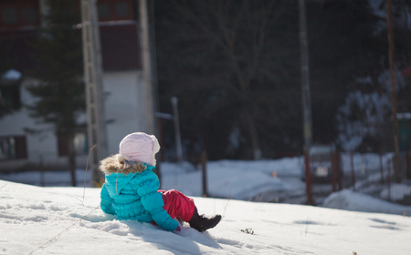 Little baby girl playing and having fun in the snow, during the winter holidaysの写真素材