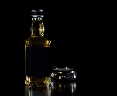 Glass bottle of whiskey on black backgroundの写真素材