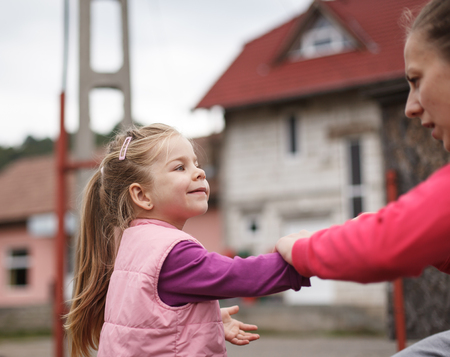 Young mother greeting her happy young daughter, family reunion timeの写真素材