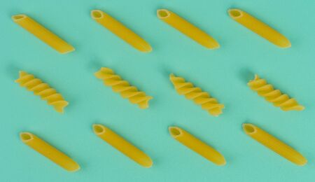 Various italian pasta on different colour cutboardの写真素材