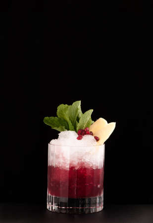 one glass cup with pomegranate drink and ice on a dark backgroundの写真素材