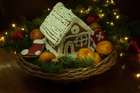 New Year Christmas cookies with tangerines and a small house in the basket next to the Christmas...