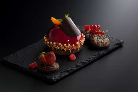 cake with berries on many decorative stone dark backgroundの写真素材