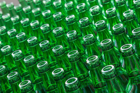 a large number of transparent glass bottles of green color closeupの写真素材