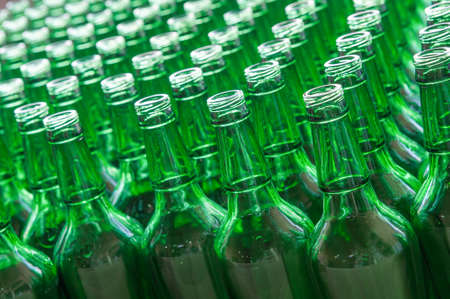 a large number of transparent glass bottles of green color closeupの写真素材
