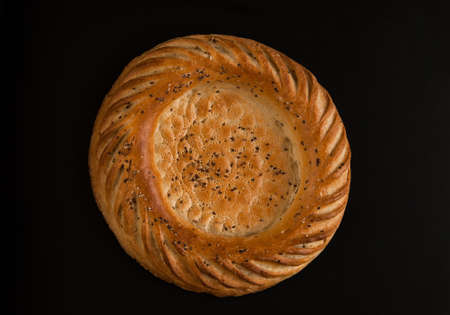 one round oriental cake closeup on a black backgroundの写真素材