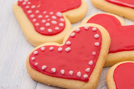 Red cookies in the shape of a heart on wooden boards close-up on Valentine's Dayの写真素材