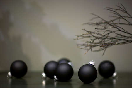 christmas tree toys matte black color and branch of a tree on a gray backgroundの写真素材