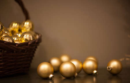 shiny and matt Christmas tree toys golden color in a wicker basket with a branch of the treeの写真素材