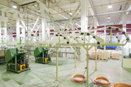 at the factory equipment for the deployment of copper tubes from rolls and cutting governed by workersの写真素材