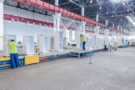 factory floor for production and assembly of household refrigerators on the conveyor belt. factory workers collect refrigerators on the conveyor beltの写真素材