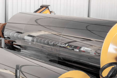 polypropylene and polyethylene are moving the shaft and roller closeup. cellophane and polypropylene...